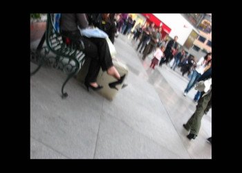 White suitcase and dangling black shoes